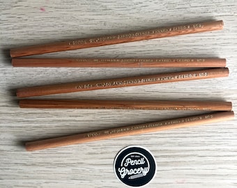 Puede incluir: Cinco lápices de madera marrón con letras doradas. Los lápices están etiquetados "JOHANN SINDELGICH (CLOSE EXTRA) CEDRO N°2".
