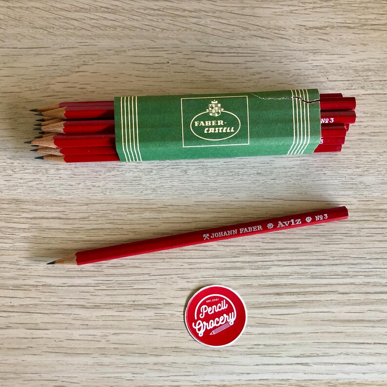Może przedstawiać: Pudełko czerwonych oł&oacute;wk&oacute;w z logo Faber-Castell i pojedynczy czerwony oł&oacute;wek z napisem "JOHANN FABER AVIZ No. 3".