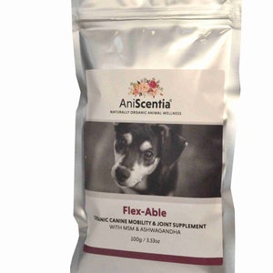 Op de afbeelding: Een zilveren zakje met een etiket met een zwart-wit afbeelding van een hond. Het etiket leest "AniScentia" en "Flex-Able", met tekst over een supplement voor de mobiliteit van honden. Het zakje bevat 100g product.