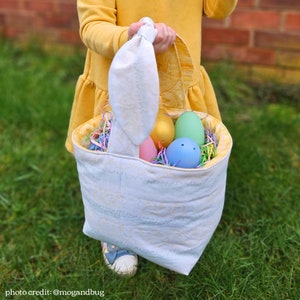 Little girl holding bunny bag with eggs