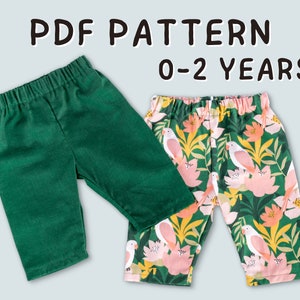 Può includere: Due paia di pantaloni verdi per neonati. Un paio è verde tinta unita e l'altro ha una stampa tropicale con uccelli rosa e fiori. Il testo "PDF PATTERN 0-2 YEARS" è visualizzato sopra i pantaloni.