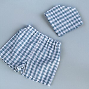 Flat lay of gingham baby shorts and a bandana bib