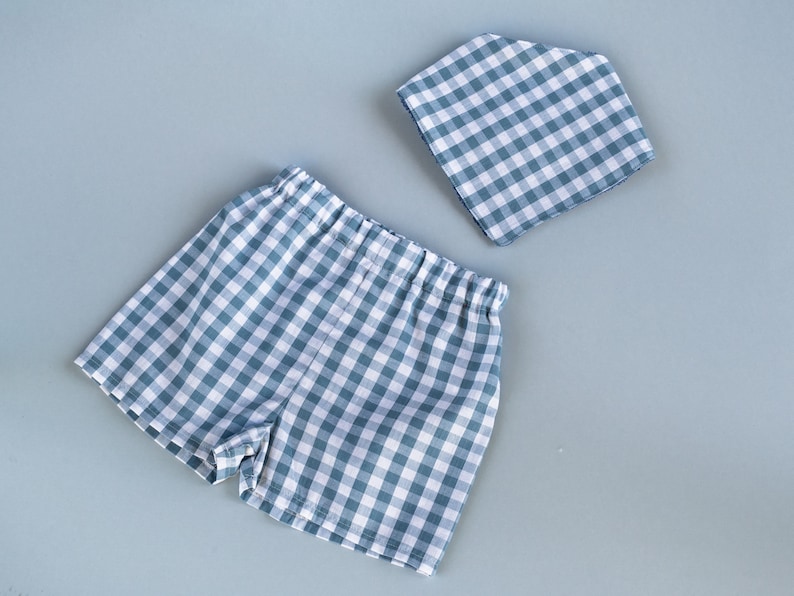 Flat lay of gingham baby shorts and a bandana bib
