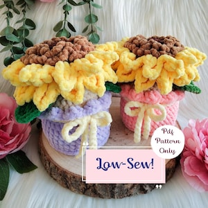 May include: Two handmade crochet sunflowers in pots. One pot is lavender with a yellow bow, the other is pink with a yellow bow. The sunflowers have yellow petals and brown centers. The text "Low-Sew!" is on the image.