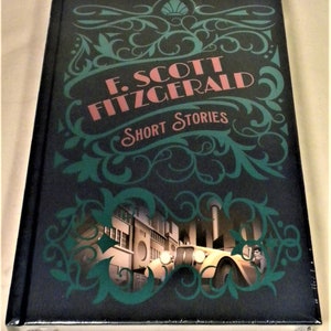 Peut inclure: Un livre relié noir avec un motif vert et or. Le titre est "F. Scott Fitzgerald Short Stories". La couverture présente une illustration d'une voiture ancienne roulant dans une rue de la ville.