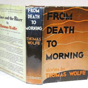 May include: Three vintage books by Thomas Wolfe are shown. The titles include "Of Time and the River" and "From Death to Morning." The book covers feature text in black and orange, with the publisher's name, Scribner's, visible on one spine.