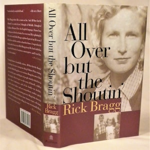 May include: A book cover with a red background and the title "All Over but the Shoutin'" by Rick Bragg. The cover features a black and white photo of a woman with a serious expression. The book is about the author's family and childhood in the South.