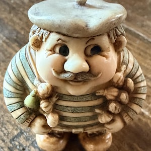 May include: A set of three ceramic mugs with a speckled, matte finish. The mugs are in shades of cream, light gray, and dark gray. Each mug has a simple, minimalist design, perfect for coffee or tea.