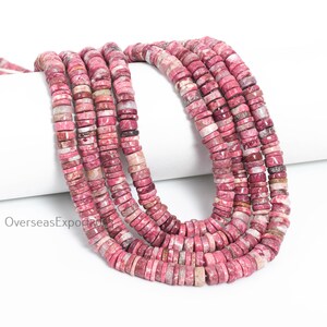 May include: A strand of small, flat, circular disc-shaped beads in varying shades of pink, magenta, and white with natural mottled patterns. The beads are strung together in a continuous loop, displaying a smooth, polished texture throughout.