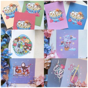 May include: A set of ten 4x6 inch printable art cards featuring various anime and cartoon characters. The cards feature a variety of colors and designs, including a blue card with a cartoon cat in a hot air balloon, a purple card with a cartoon dragon, and a pink card with a cartoon character eating ramen.