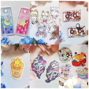 May include: A collection of colorful stickers featuring various characters and designs. There are stickers of anime characters, a cartoon ramen bowl, a Totoro character, and a cassette tape with a Totoro character inside. The stickers are on a white background.