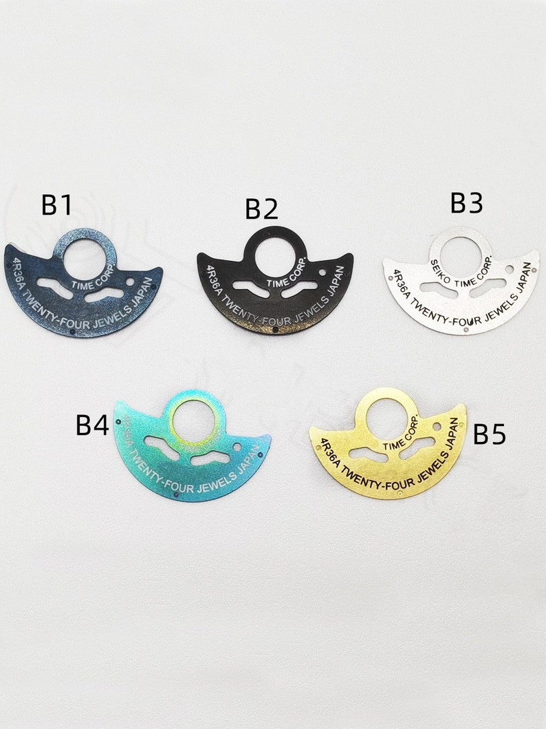 May include: Five different watch movement parts, each with a different color and finish. The parts are all shaped like a crescent moon and have the text "4R36A TWENTY-FOUR JEWELS JAPAN" printed on them.