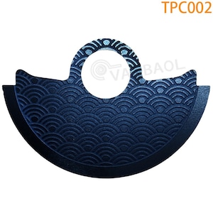 May include: A black metal disc with a circular hole in the center and a decorative pattern of overlapping semicircles. The disc has a slightly curved shape and a smooth, polished finish.
