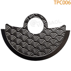 May include: A black metal watch part with a circular hole and a pattern of overlapping semicircles. The part is labeled "TPC006".