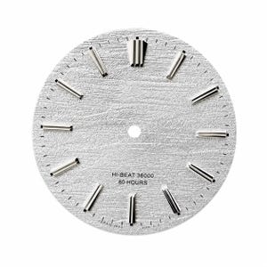 May include: A circular silver watch dial with a textured, wood-grain-like surface. It features polished silver baton hour markers, a double marker at the twelve o'clock position, and black text reading HI-BEAT 36000 80 HOURS near the bottom.
