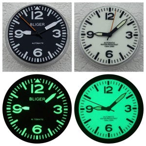 Puede incluir: Cuatro relojes redondos con esferas en blanco y negro. Los dos relojes superiores muestran la hora, con la esfera negra que muestra la palabra "BLIGER" y "AUTOMATIC". Los dos relojes inferiores brillan en verde en la oscuridad. La esfera del reloj tiene los números 12, 3, 6 y 9.