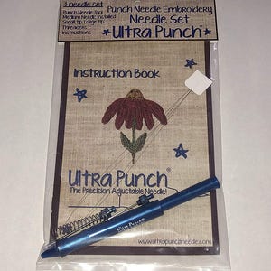 May include: A blue punch needle tool with a spring and a white instruction booklet with a flower design. The booklet has the text "Instruction Book" and "Ultra Punch The Precision Adjustable Needle!" The packaging has the text "3 needle set Punch Needle Embroidery Needle Set *Ultra Punch*"