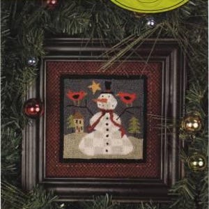 May include: A framed punch needle embroidery pattern featuring a snowman with red cardinals and a star. The pattern is titled "673 - Snow Drifters" and is 5" x 5" in size. The frame is dark brown wood with a red mat.