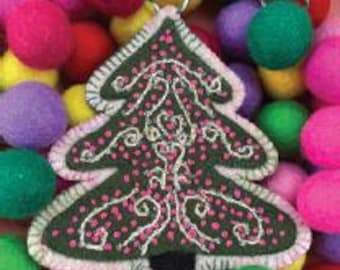May include: A green felt Christmas tree ornament with white stitching and pink accents. The ornament is surrounded by colorful felt balls in shades of pink, purple, green, and yellow. The tree has a white scalloped edge and a loop for hanging.