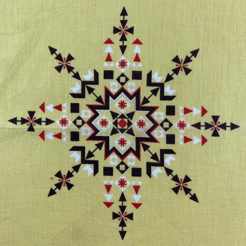 May include: A geometric starburst pattern in black, red, and white on a pale yellow background. The design features arrows, squares, and triangles arranged in a symmetrical pattern, creating a striking visual effect. The overall theme is a decorative textile design.