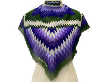 May include: A purple, green, and white geometric patterned scarf with a frayed edge. The scarf is on a white mannequin. The brand name "Kessy Milano" is visible on the scarf.