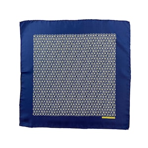 May include: A square blue pocket square featuring a central geometric pattern of small yellow shapes on a dark blue background, surrounded by a solid blue border. The text HERMES PARIS is printed in small yellow letters in the bottom right corner.