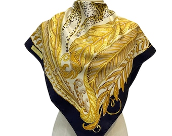 May include: A silk scarf with a black background and a gold and white pattern. The pattern features a leopard print and a floral design.