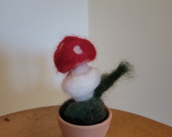 Hongo venenoso de lana afieltrado con aguja, hecho a mano, una decoración caprichosa para el hogar.