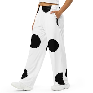 Puede incluir: Pantalón blanco de pierna ancha con estampado de lunares negros. El pantalón tiene cintura elástica y bolsillos.