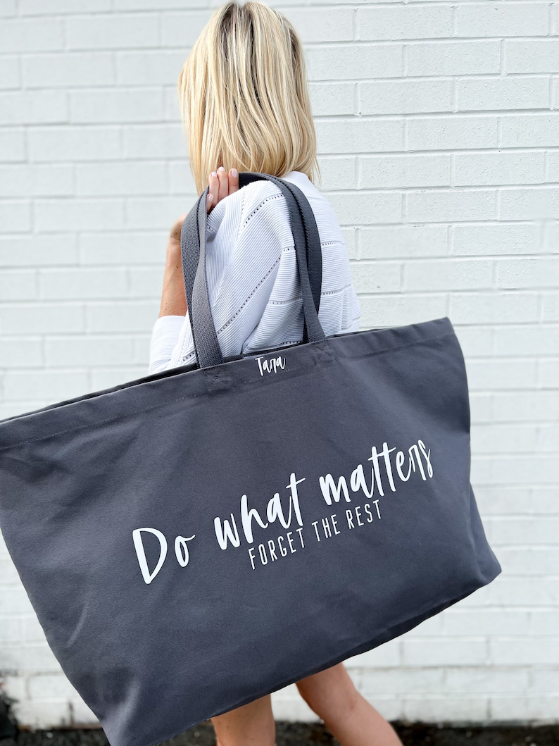 Oversized tote in a thick durable grey canvas which says “Do what matters, forget the rest”. These totes come in 4 different text options, two text colors and 4 tote color options.