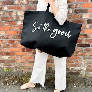 Oversized tote in a thick durable black canvas which says “See the good”. These totes come in 4 different text options, two text colors and 4 tote color options.