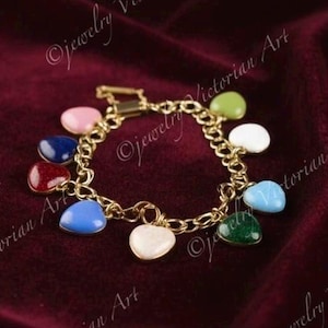 May include: A gold-tone chain link charm bracelet featuring multiple heart-shaped charms in various colors including pink, blue, red, white, green, and light blue. The bracelet has a rectangular clasp closure and a polished metallic finish.