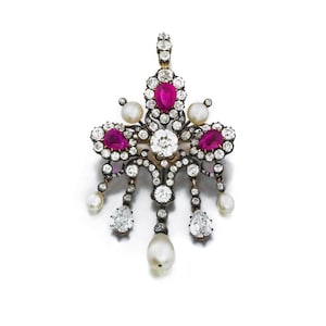 May include: An ornate pendant featuring a central round diamond, surrounded by smaller diamonds and accented with vibrant pink gemstones. The design includes dangling pear-shaped diamonds and lustrous pearls, set in a gold-toned metal.
