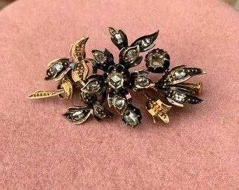 May include: A vintage gold and silver brooch featuring a floral design with multiple diamond accents.