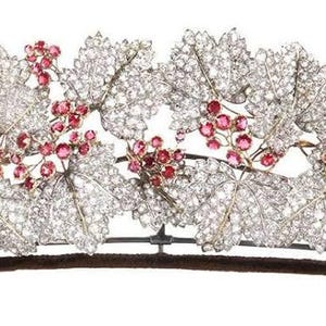 Puede incluir: Una diadema delicada con un diseño de vid, hojas engastadas con diamantes y racimos de piedras preciosas rosas.