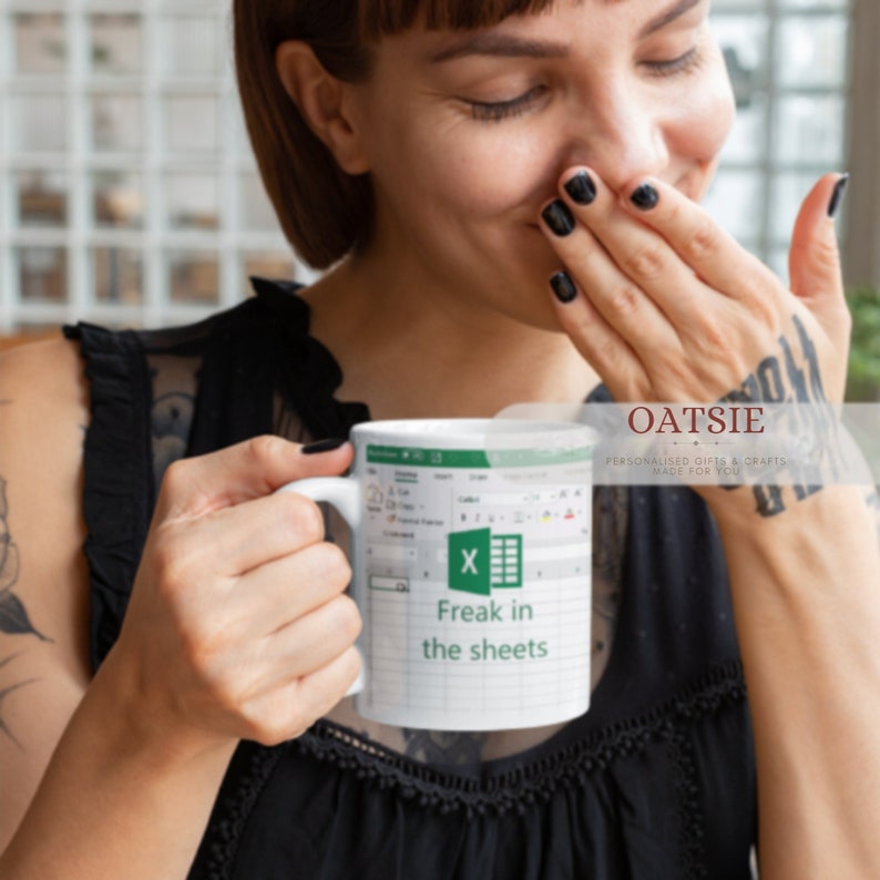 K&ouml;nnte beinhalten: Eine wei&szlig;e Keramiktasse mit einem gr&uuml;nen Microsoft Excel-Logo und dem Text "Freak in the sheets".