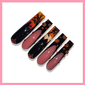 May include: Five long, black and nude-colored fake nails with Halloween-themed designs. The nails feature a black cat silhouette, a spiderweb, and orange pumpkins with black faces.