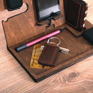 Pu&ograve; includere: Un organizzatore in legno con slot per telefono, orologio, chiavi e penna. C'&egrave; una carta di credito e un portachiavi in ​​pelle nell'organizzatore.