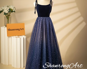 May include: A navy blue velvet and tulle evening gown with a fitted bodice and a full skirt. The skirt is adorned with silver glitter stars.
