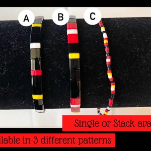 May include: Three different styles of black, red, white, and yellow beaded bracelets. The bracelets are labeled A, B, and C. Single or stack available. Available in 3 different patterns.
