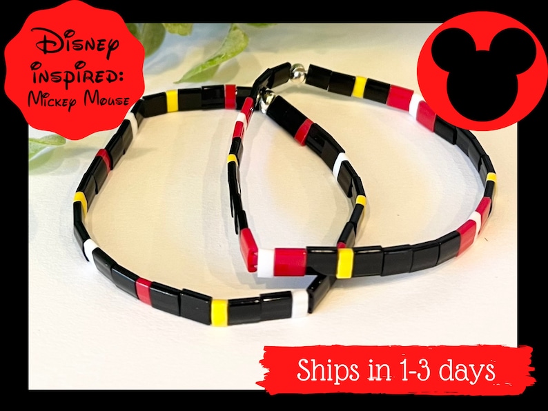 May include: Two black, red, yellow, and white beaded bracelets inspired by Mickey Mouse.