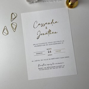 Puede incluir: Una invitaci&oacute;n de boda blanca con letras doradas anunciando el matrimonio de Cassandra y Jonathan. La boda tendr&aacute; lugar el s&aacute;bado 24 de marzo de 2024 a las 3:30 PM en el Hotel de Ville de Br&eacute;tigny-sur-Orge. La recepci&oacute;n tendr&aacute; lugar despu&eacute;s de la ceremonia. Por favor, responde antes del 1 de marzo de 2024.