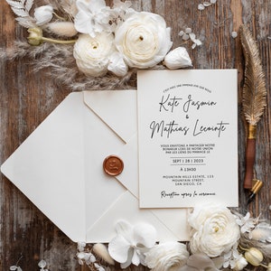 Puede incluir: Una invitación de boda blanca con un sello de cera dorado. La invitación es para Kate Jasmin y Mathias Lecointe. La boda se celebrará el 28 de septiembre de 2023 a la 1:30 PM en Mountain Hills Estate en San Diego, California. La invitación dice "C'est avec une immense joie que nous vous invitons à partager notre bonheur lors de notre union par les liens du mariage le Sept 1 281 2023 A 13H30 Mountain Hills Estate, 123 Mountain Street, San Diego, CA Reception après la cérémonie."
