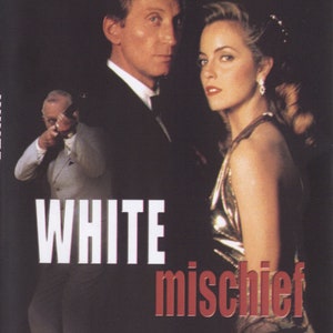 Peut inclure: Affiche de film pour le film "White Mischief" avec Charles Dance et Greta Scacchi. L'affiche présente un fond noir avec le titre en blanc et rouge. Les acteurs sont représentés en gros plan, Dance en smoking et Scacchi en robe dorée. L'affiche comprend également une classification "M" pour les adultes.