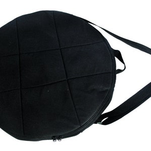 May include: Black padded round bag with a zipper closure and an adjustable shoulder strap.