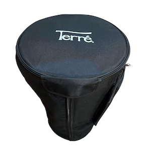 May include: Black Terre drum case with a zippered closure and a side pocket. The Terre logo is printed in white on the top of the case. The case is designed to protect a drum during transport and storage.