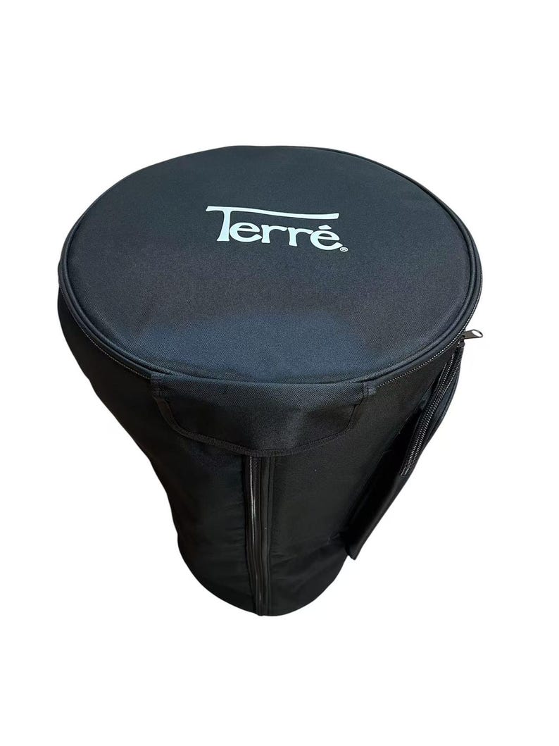 May include: Black Terre drum case with a zippered closure and a side pocket. The Terre logo is printed in white on the top of the case. The case is designed to protect a drum during transport and storage.