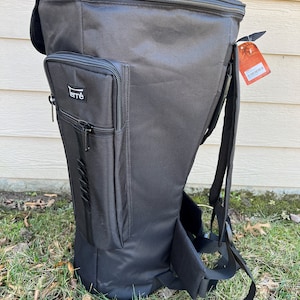 May include: Black backpack with a tall, tapered design. Features a zippered main compartment, a smaller front pocket with the brand name "ferr&egrave;", and adjustable shoulder straps. The bag is made of a durable, water-resistant material, suitable for outdoor use.