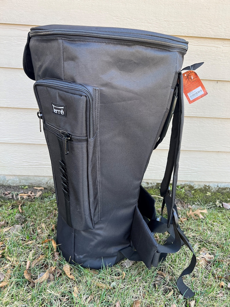 May include: Black backpack with a tall, tapered design. Features a zippered main compartment, a smaller front pocket with the brand name "ferr&egrave;", and adjustable shoulder straps. The bag is made of a durable, water-resistant material, suitable for outdoor use.