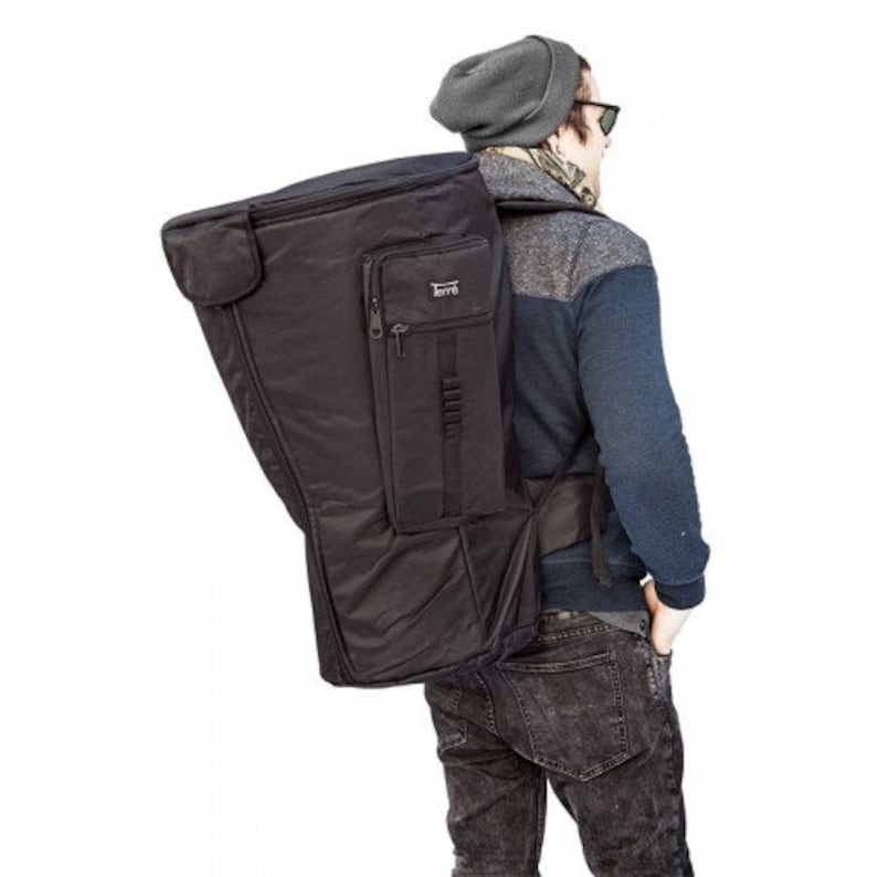 May include: A black instrument case with the brand name "Terr&eacute;" on the front is being carried over the shoulder. The case has multiple pockets and a zipper closure. The person carrying the case is wearing a gray beanie and sunglasses.